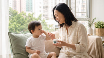 Mother applying fragrance-free cream to her toddler's inner elbow crease at home in Hong Kong, where flexural eczema most often flares